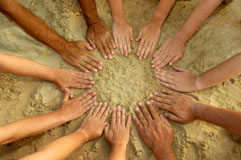 Circle of hands in the sand